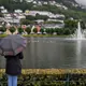 A woman standing with her back to the camera, holding an umbrella on a rainy day in Bergen