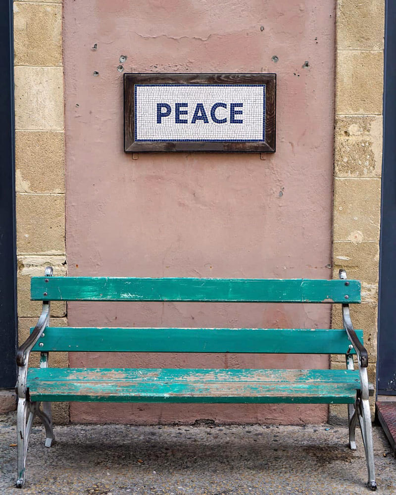 This little bench is just before the border crossing on the Greek side of the Green Line. The mosaic above says Peace - while the wall behind is dotted with bullet holes.