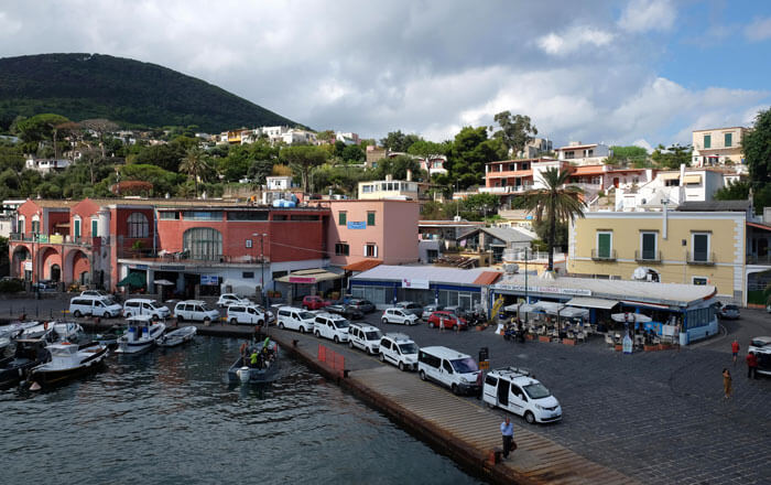 Arriving in Ischia Porto. The dark pink building with the arched windows houses the ticket offices for all services apart from Alilauro.