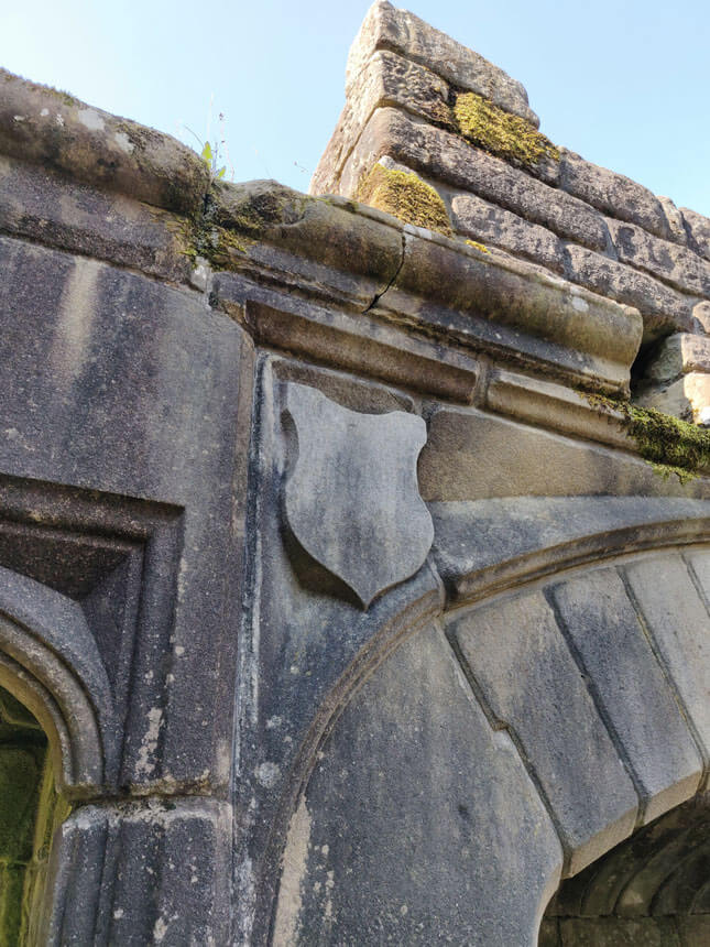 A carved shield above one of the arched doors