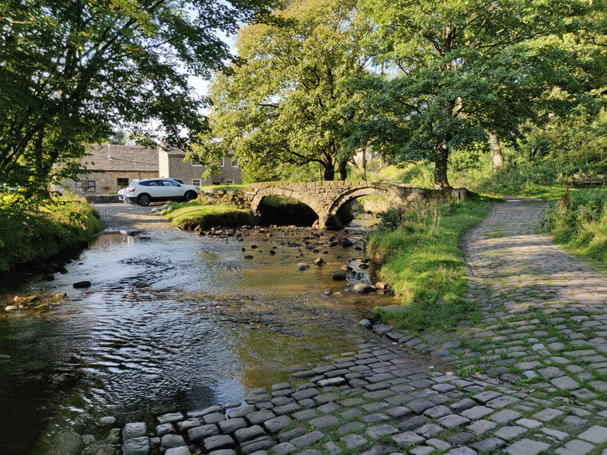 Wycoller's delightfully wonky Pack Horse Bridge, with the ford in front of it. 