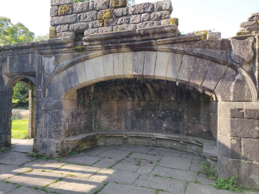 A huge fireplace with an arched roof and stone seats all the way around.