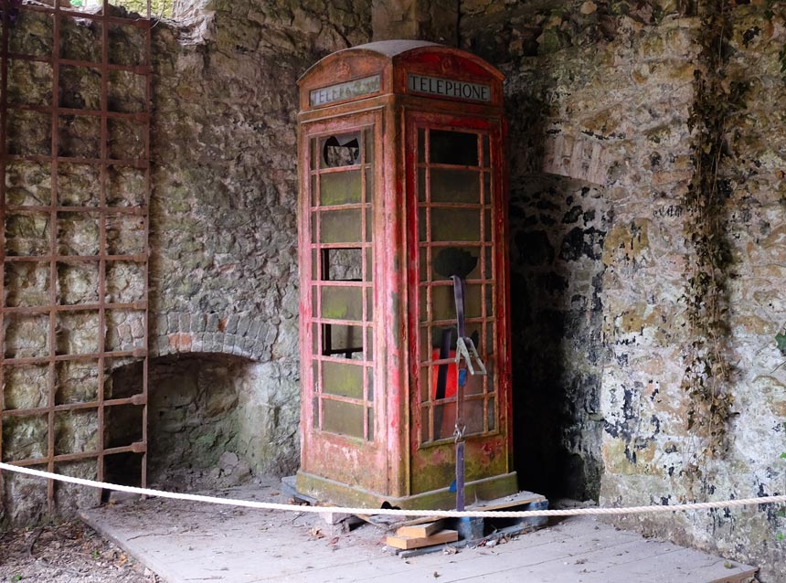 A rusty old red telephone box that was used in I'm A Celebrity... Get Me Out Of Here! is in the corner of an old stone outbuilding.