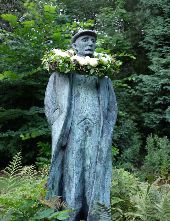 The statue of Ammon Wrigley in Uppermill with his garland of white roses for Yorkshire Day