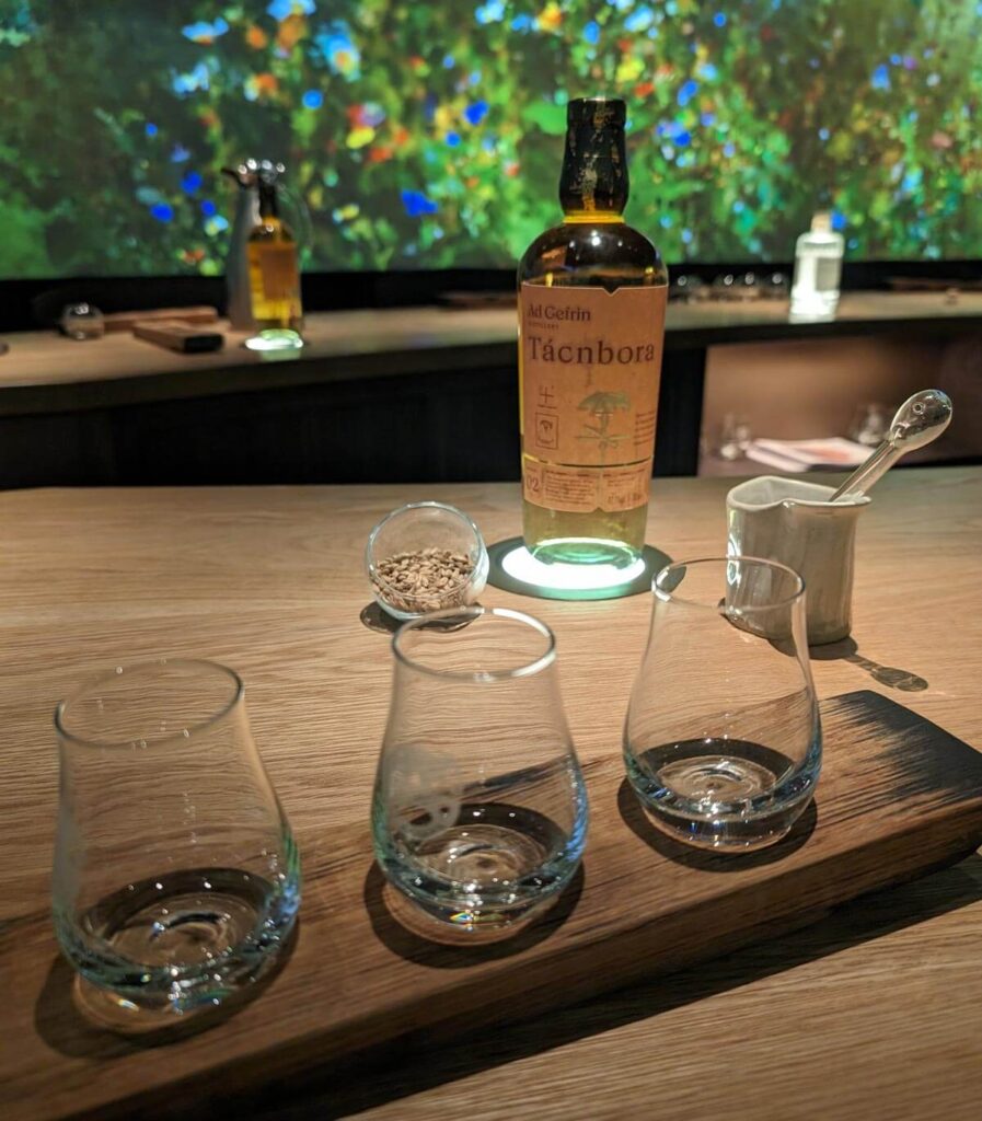 The tasting room at Ad Gefrin. A bottle of whisky is on a table with three tasting glasses in front.