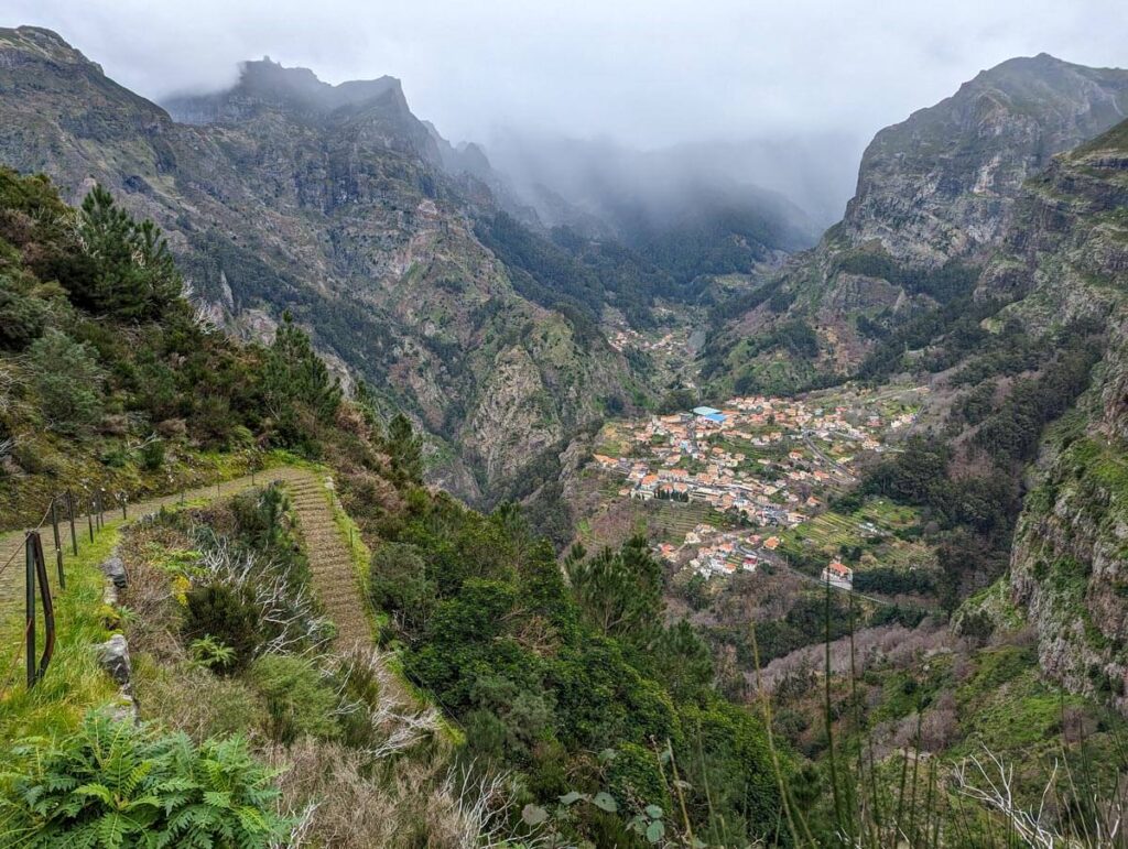 The Nuns' Path from Eira do Serrado to Curral das Freiras. A path winds down the mountain towards the village at the bottom of the hill.