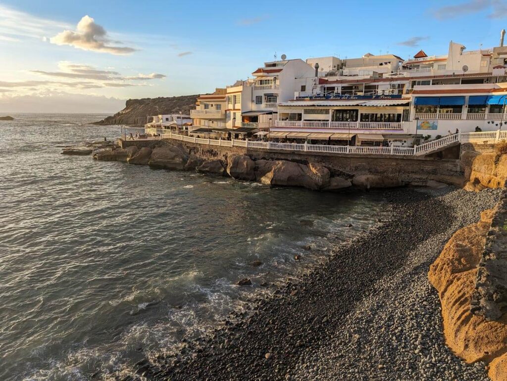 A small pebbly beach in La Caleta. There is a row of fish restaurants on the other side of the beach.