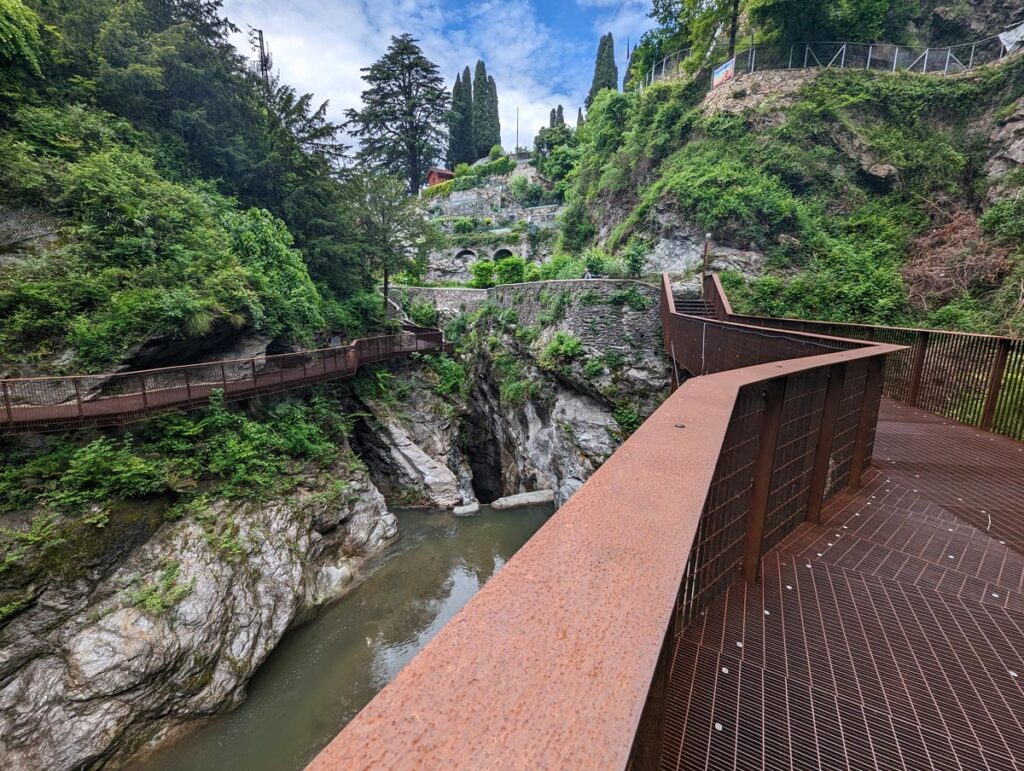 Rust-coloured metal walkways along the edges of a rocky gorge with a river at the bottom