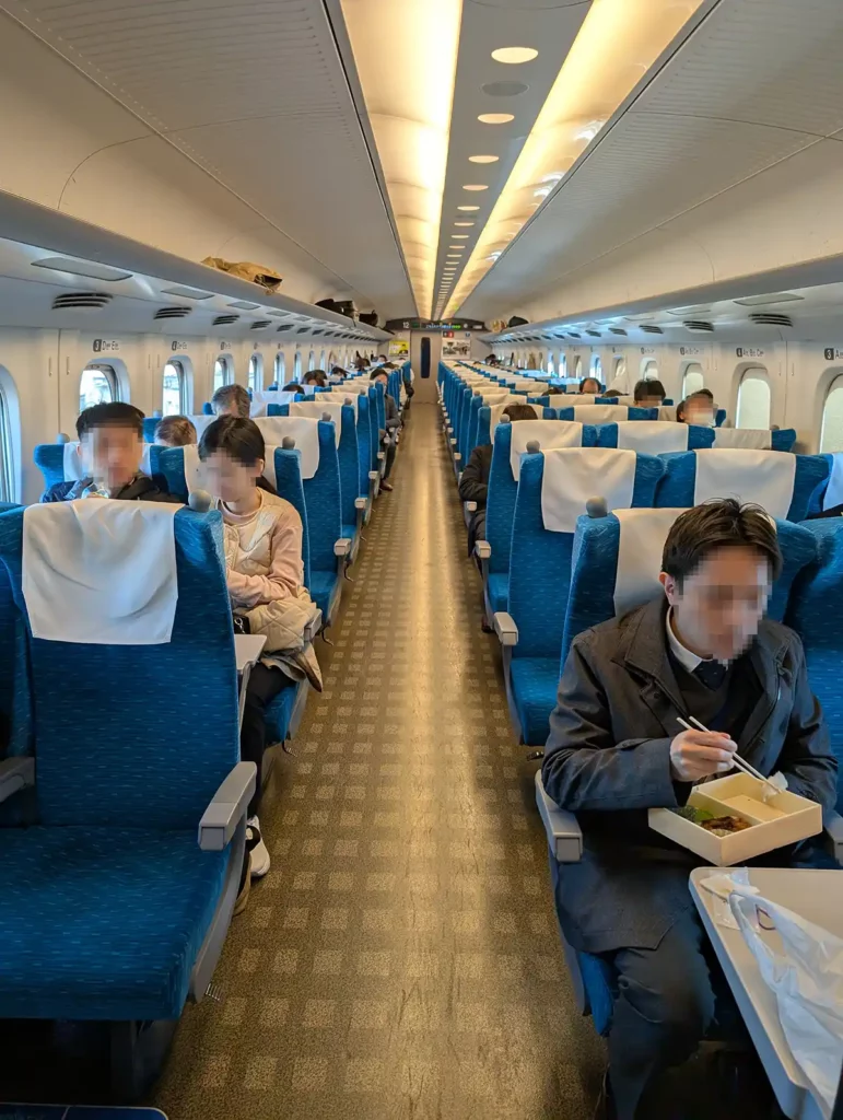 A bullet train coach with people eating