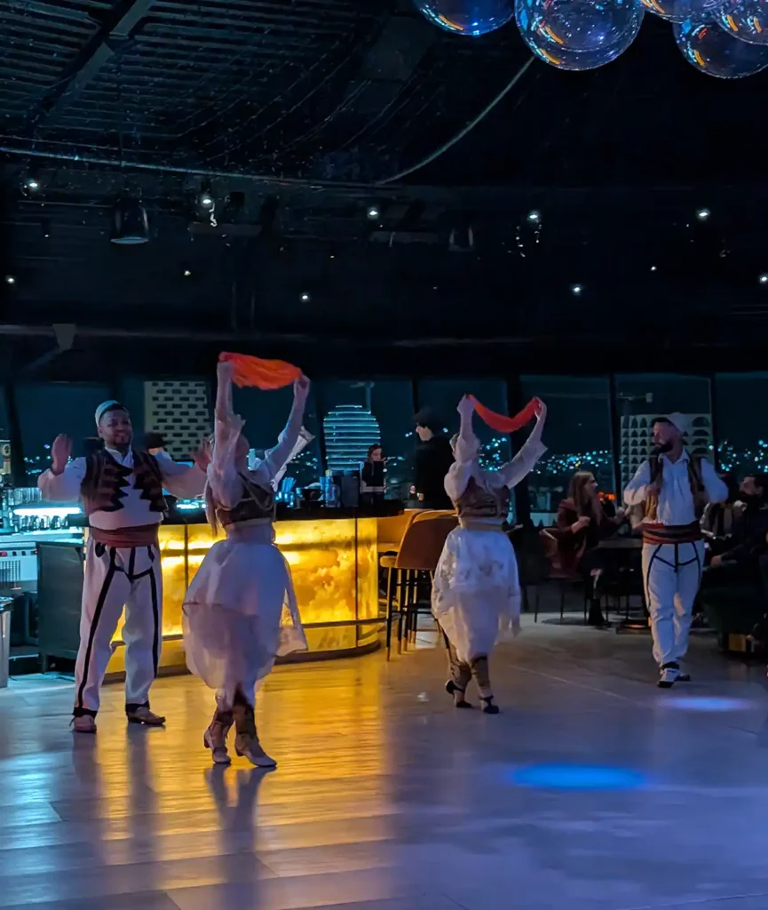 Traditional Albanian dancers at a modern bar