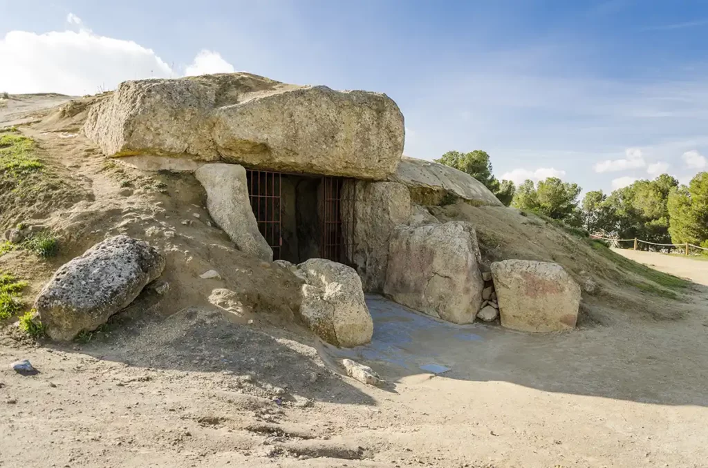 A low mound with a simple stone entryway leading to a burial chamber