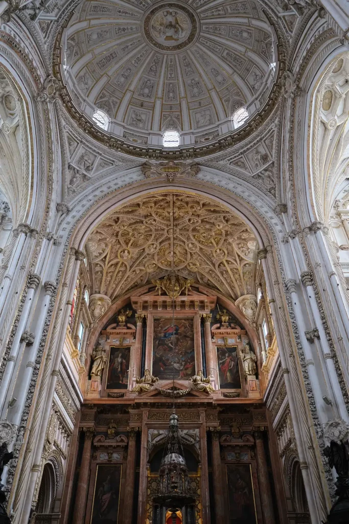 The Renaissance part of the Mezquita-Cathedral in Córdoba. A giant white, ornate roof with gilded paintings and plasterwork.