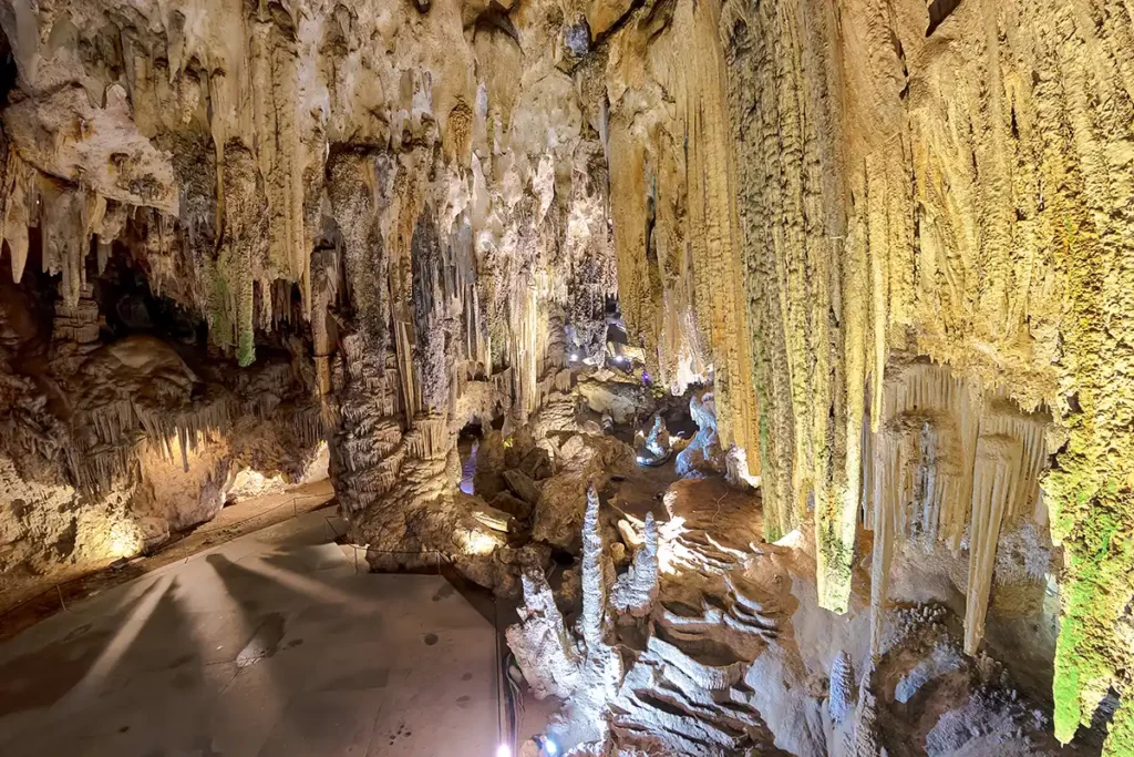 A magnificent cave, with lots of stalactites hanging from the roof 