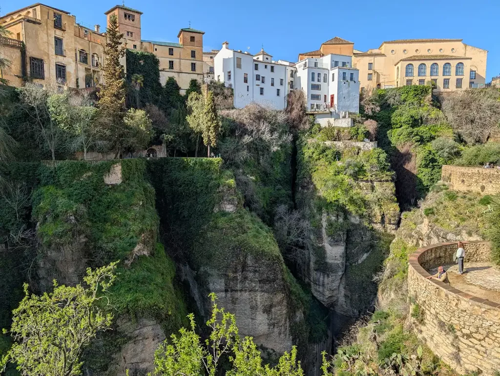 The beautiful gorge in Ronda. A deep, wooded gorge with magnificent old buildings at the top. There are viewing points on the side of the gorge where I'm stood.