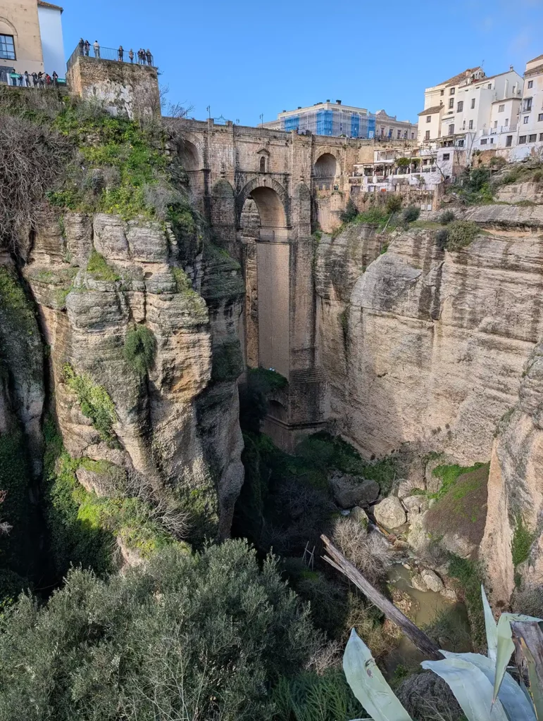The Puente Nuevo in Ronda, one of the best day trips from Malaga. A towering old stone bridge crosses a narrow but very deep gorge.