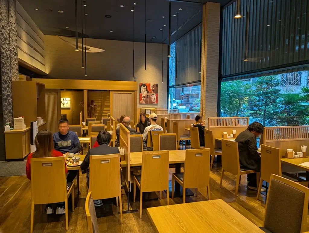 The hotel restaurant where breakfast is served each morning. There are lots of tables in light wood.