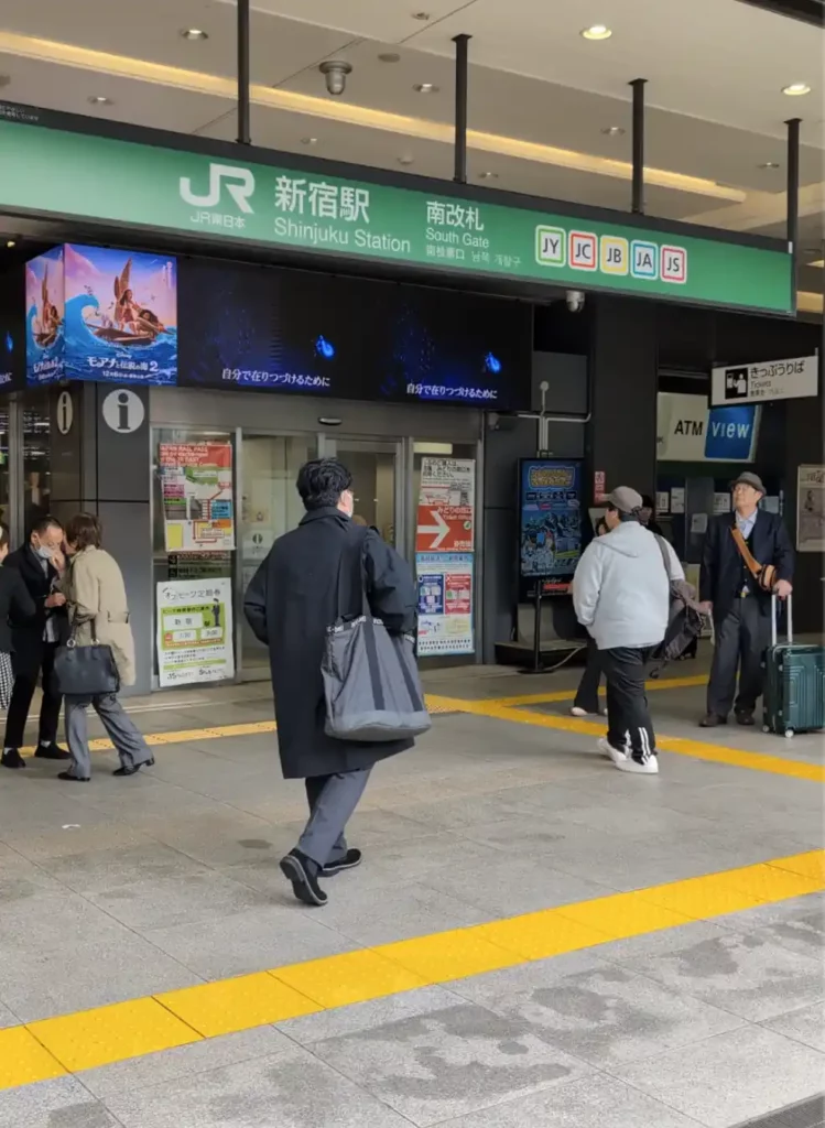 The South Gate of Shinjuku Station is only around 5 minutes' walk from the hotel. There are logos for the different train and metro lines, a sign for an ATM and a sign for an information point.