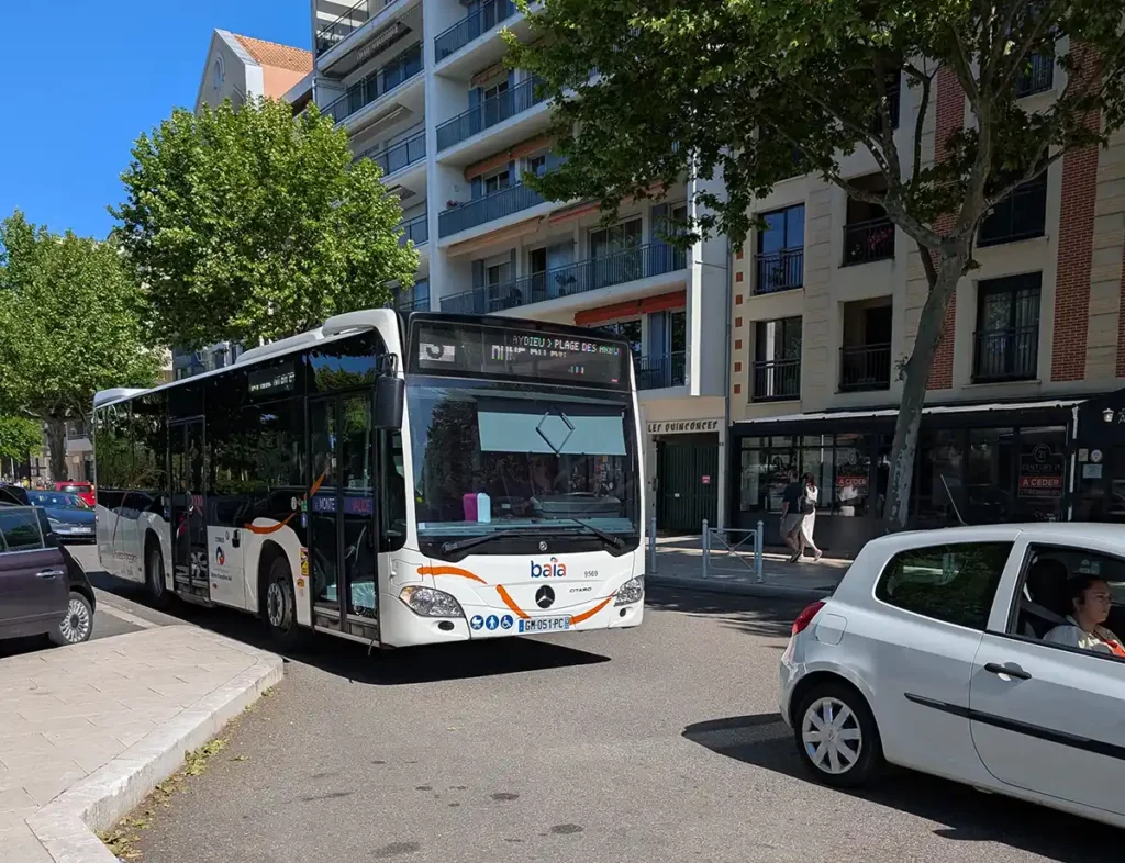 A bus arriving at a bus stop. The destination board reads Line 3, Dune du Pilat