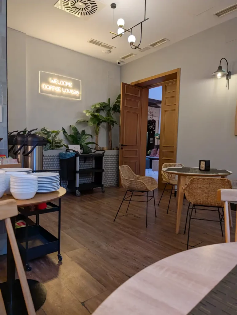 The coffee shop and breakfast room. An airy room with stylish wooden furniture and neon sign