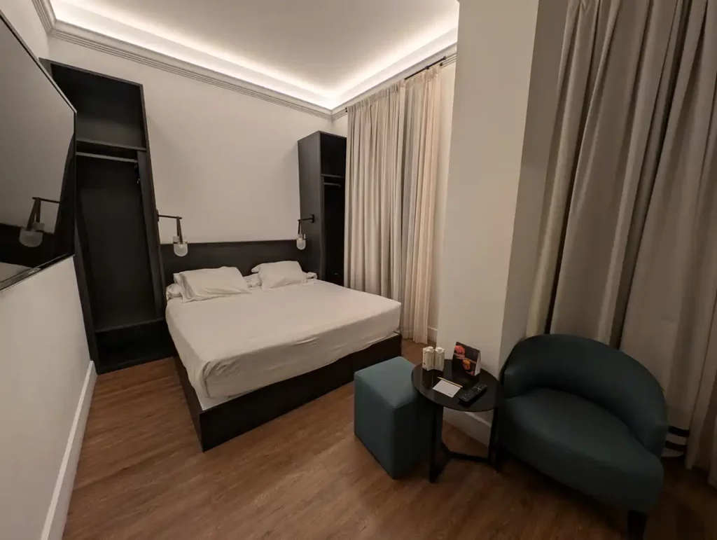 A private room at TOC Hostel Malaga. There is a large double bed with shelving almost to the ceiling on either side.
