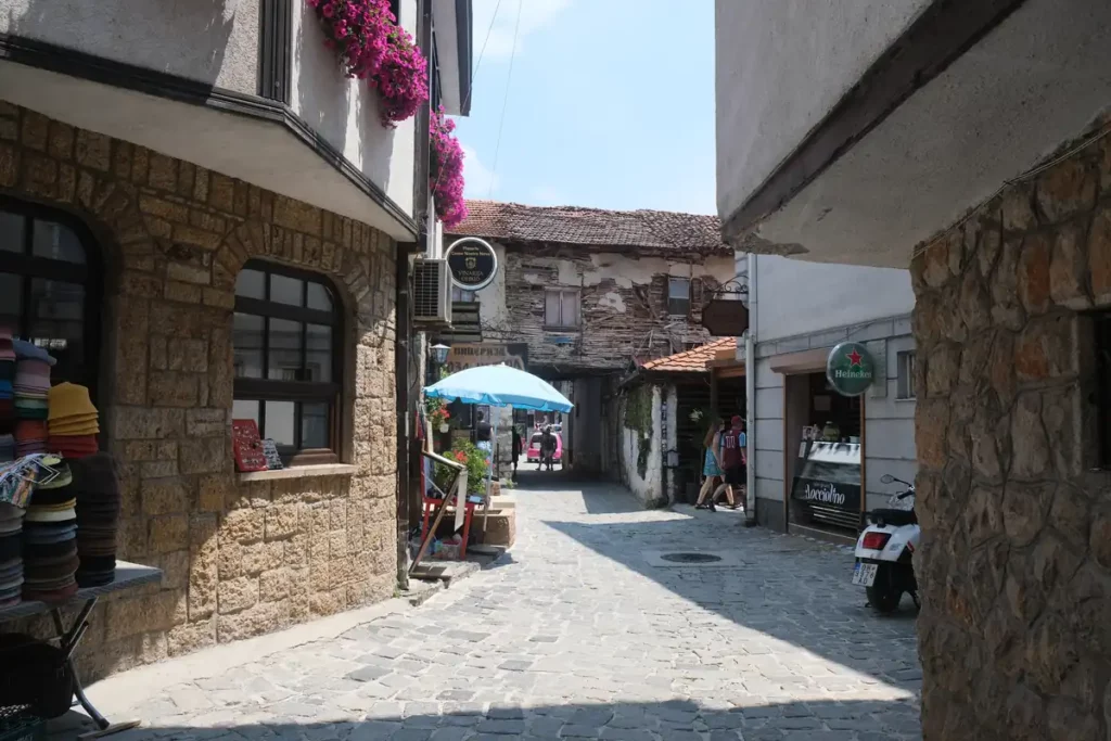 A street in Ohrid old town, with overhanging buildings and colourful flowers