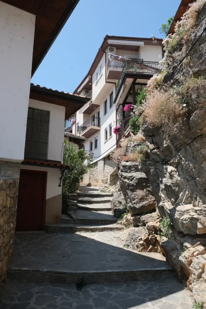 A narrow, stepped street in Ohrid old town, with white buildings where the top floors are wider than the ones below.