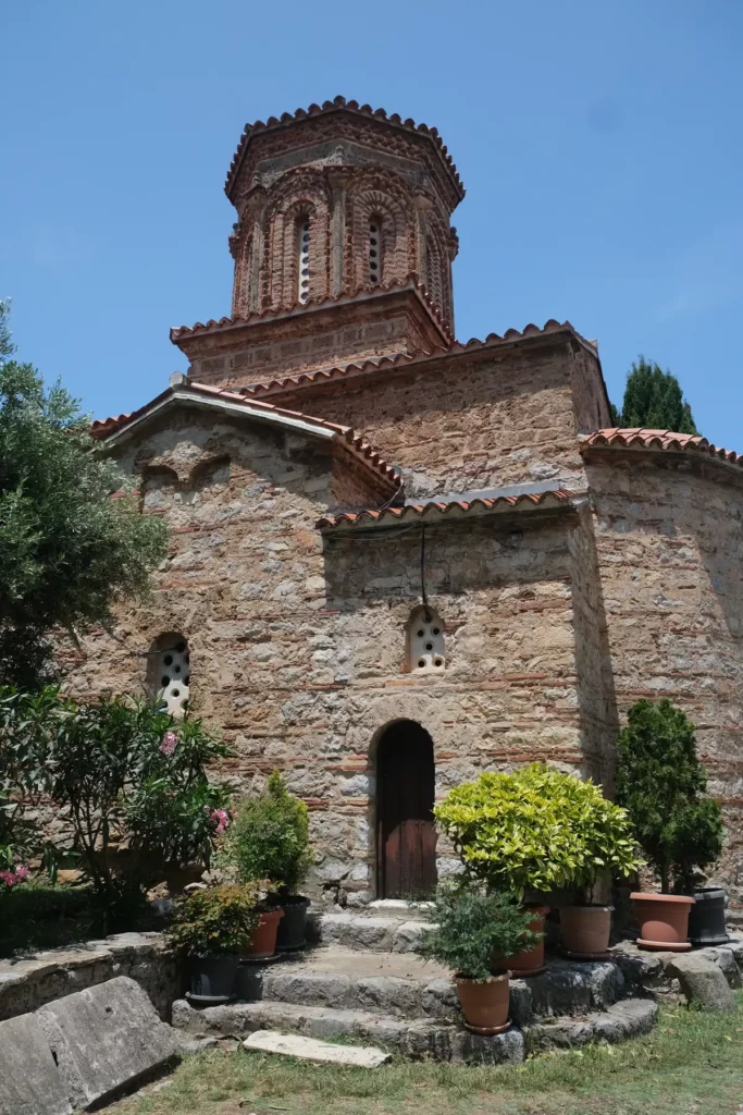 The church at St Naum. An old Byzantine church with plants and flowers around the outside. 