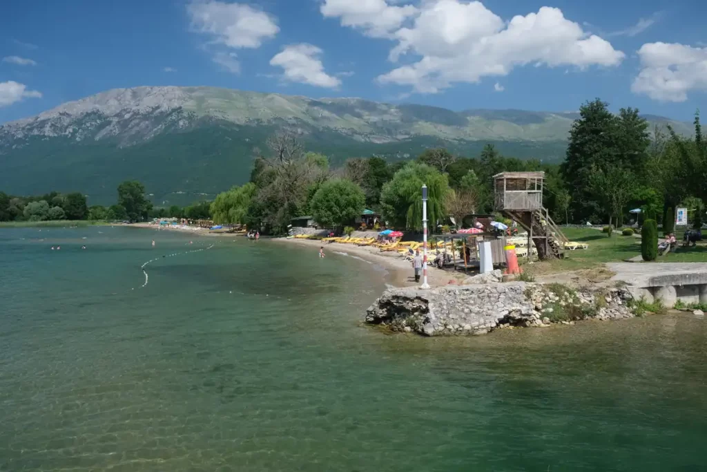 A beach on a lake, with yellow sunloungers