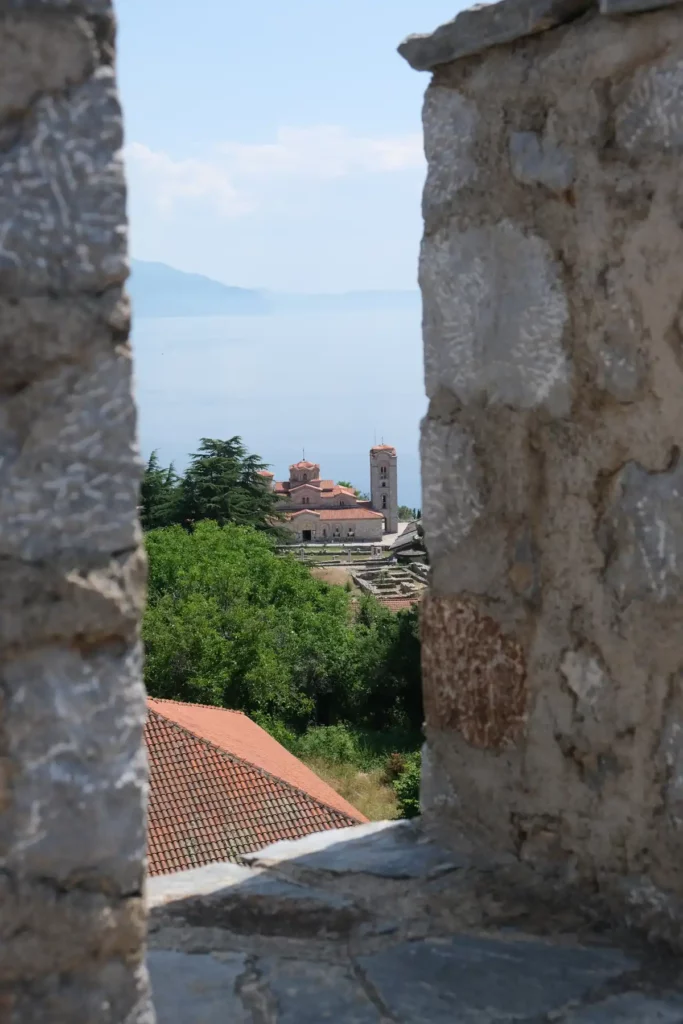 A view through stone castle ramparts down to an ancient Byzantine church
