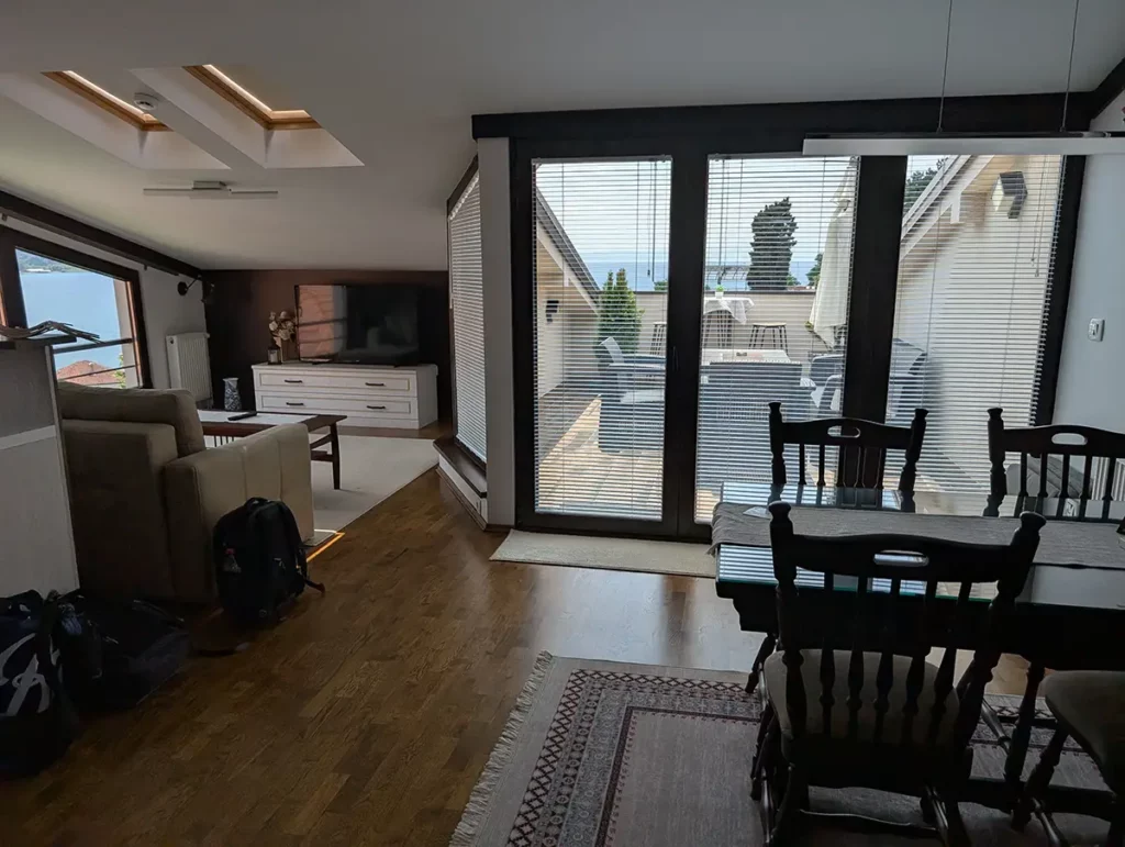 An open plan loft apartment living room with doors leading out to a terrace