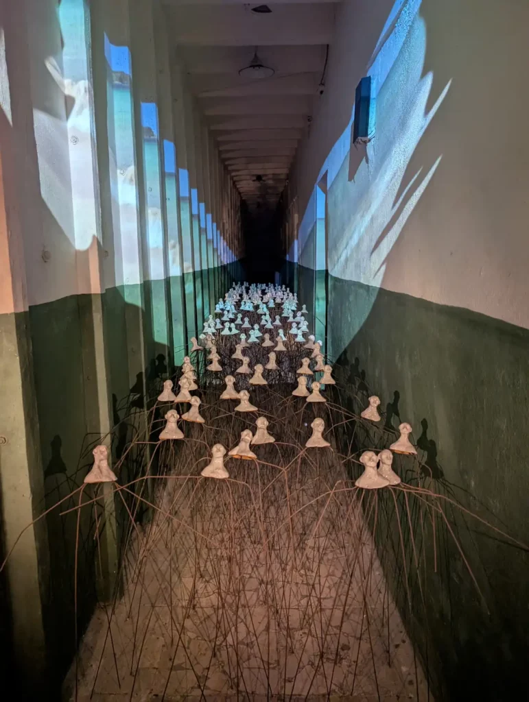 An art installation with lots of clay heads suspended in a bunker corridor