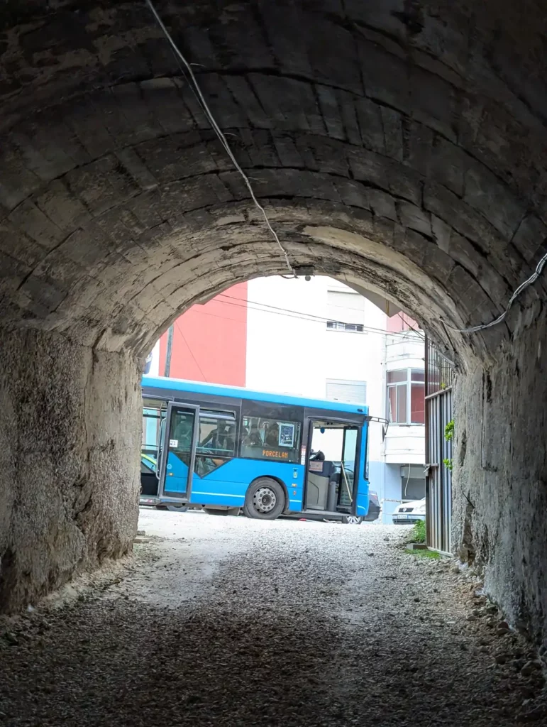 A blue city bus stopped at the end of the Bunk'Art 1 tunnel