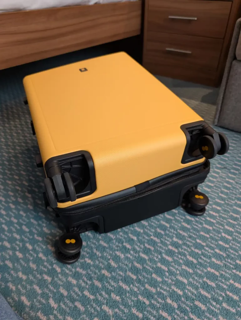 A suitcase on its back, showing the four spinning wheels