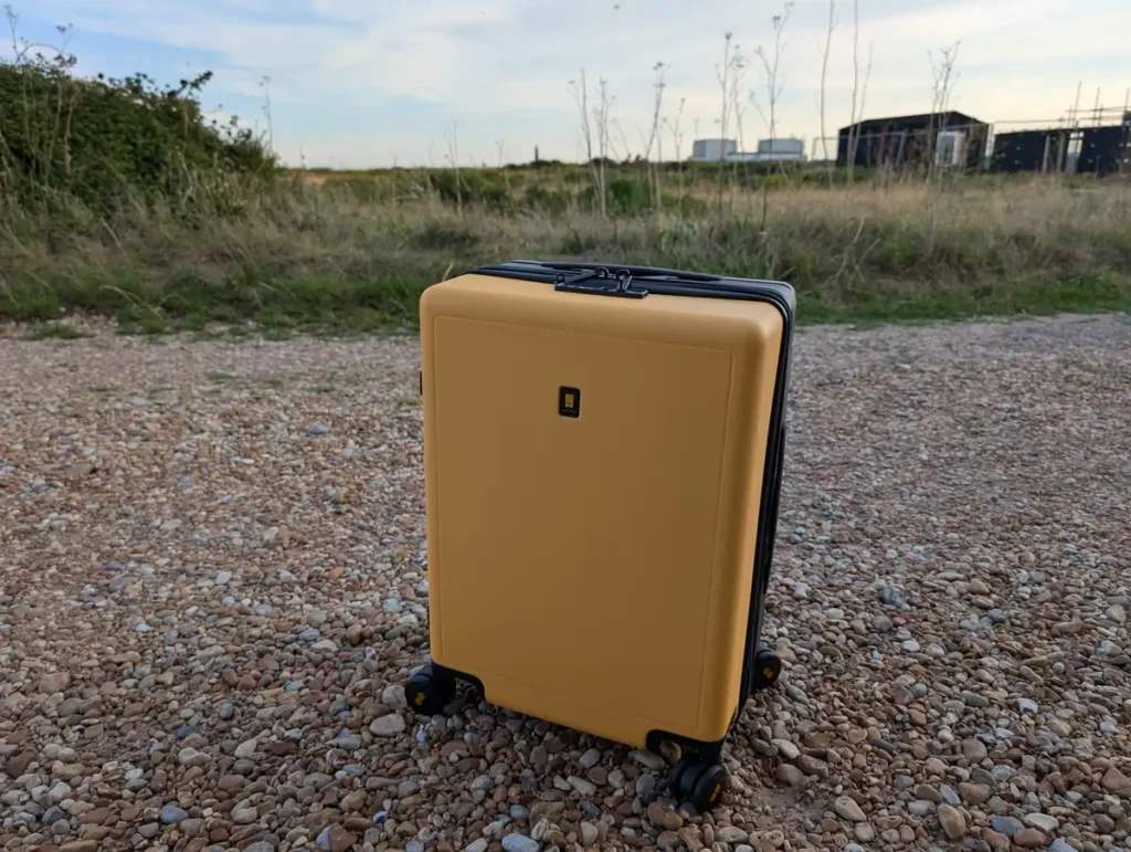 A yellow suitcase on a gravel road