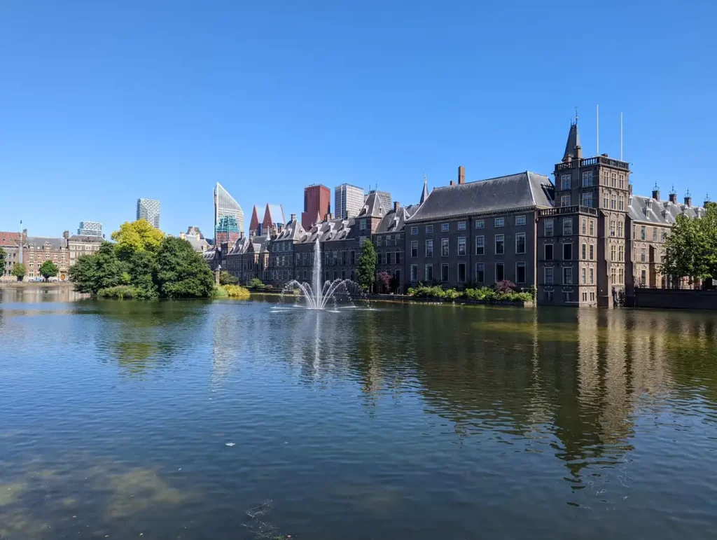 Beautiful grand and historic buildings around a lake, with a fountain in the middle