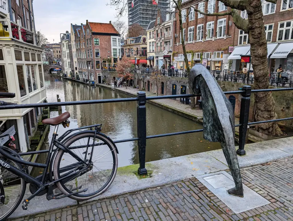 A canal view in the centre of Utrecht, one of the best day trips from Amsterdam. The canal is at a lower level and there are old warehouses. 