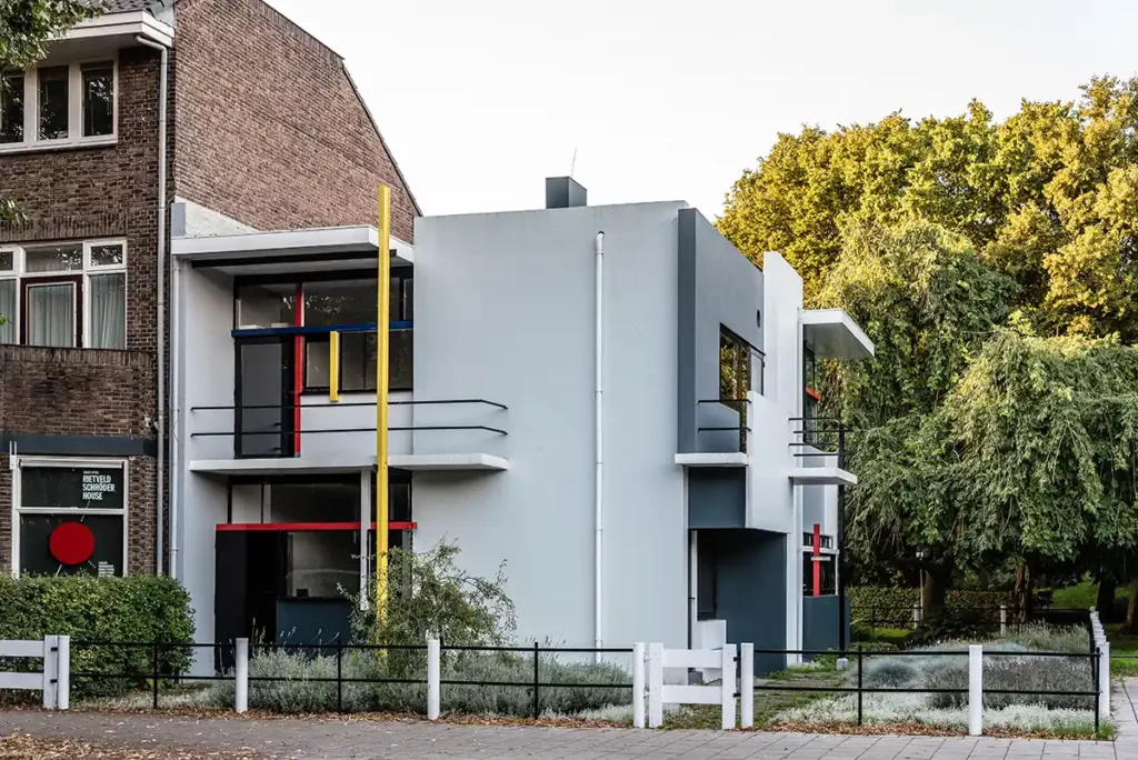 A square, white house with primary-coloured accents