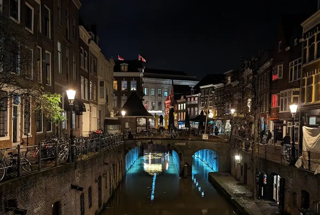 A winter evening in Utrecht, with bright lights reflecting on the canal
