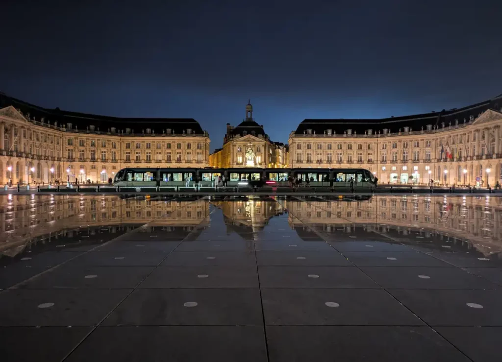A grand, symmetrical square. The buildings are reflected in the Miroir d'Eau, a shallow pool in front of the square. The Place de la Bourse and Miroir d'Eau are two of the top places to see in Bordeaux
