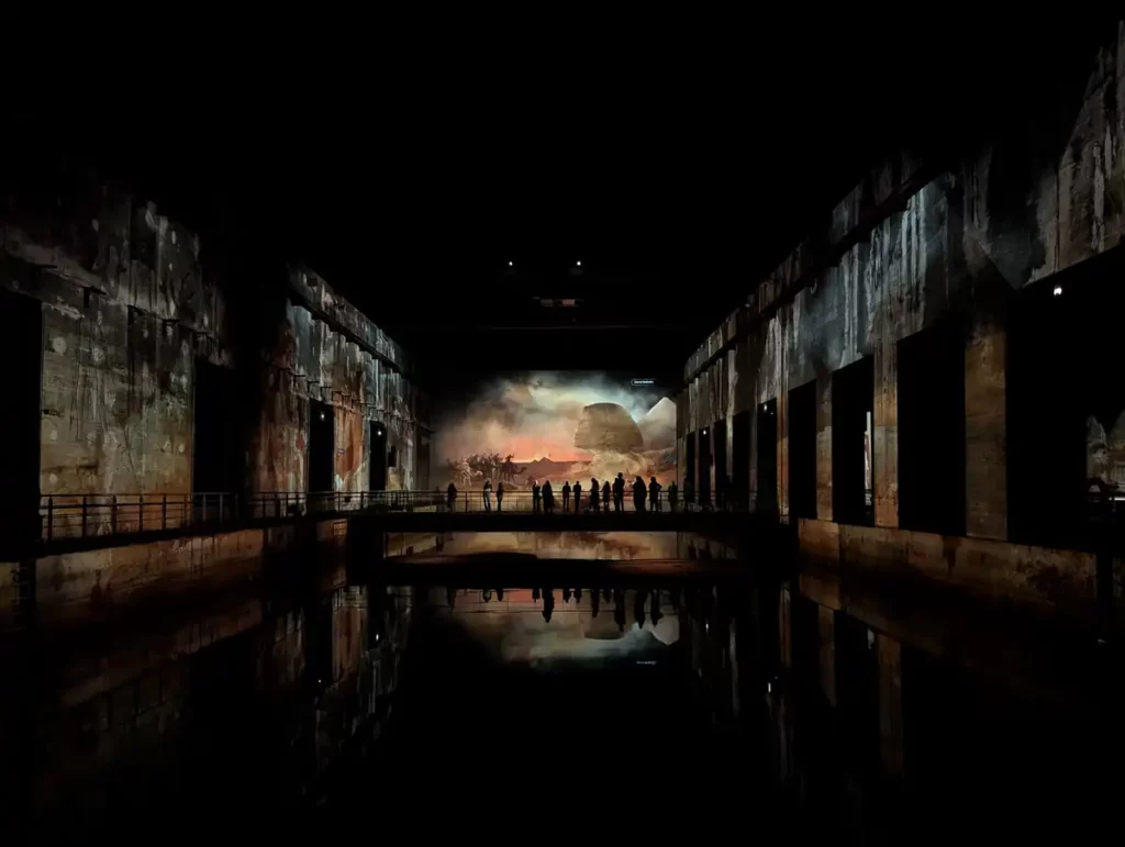 A vast, dark space with a show being projected onto the walls