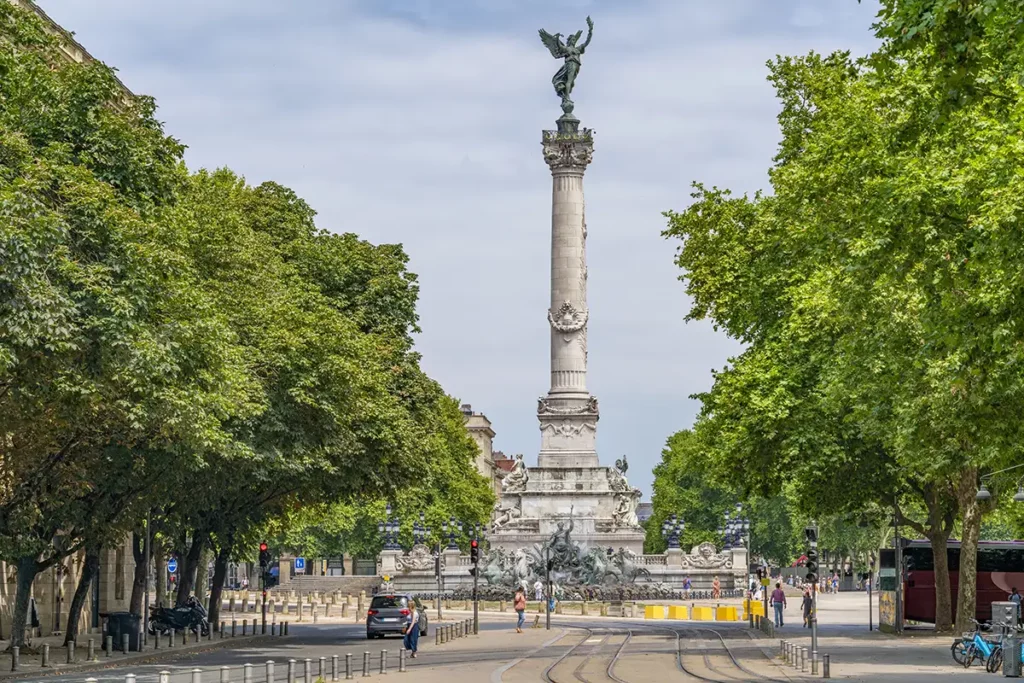 A large square in Bordeaux. There's a tall pillar with a sculpture on top.