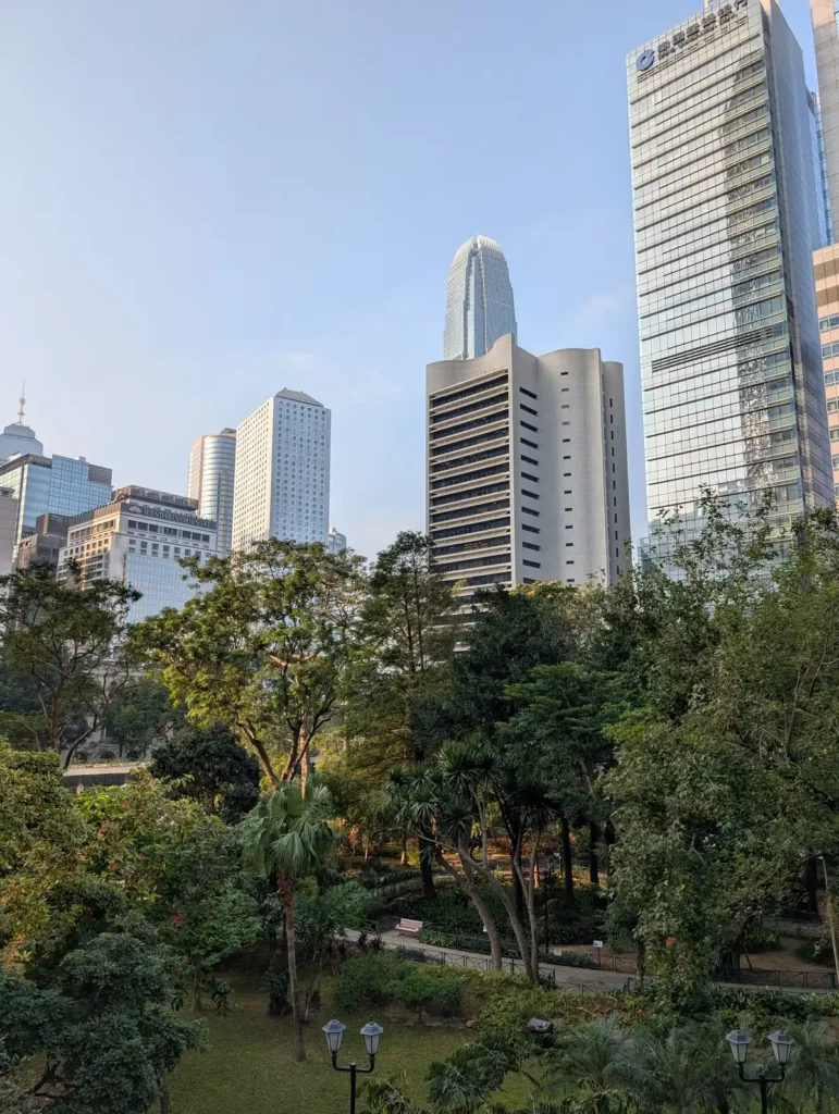 A green park with skyscrapers behind