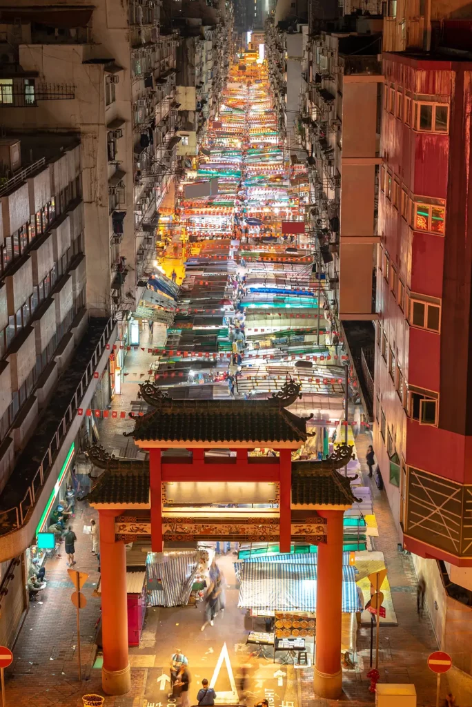 A long straight street filled with market stalls