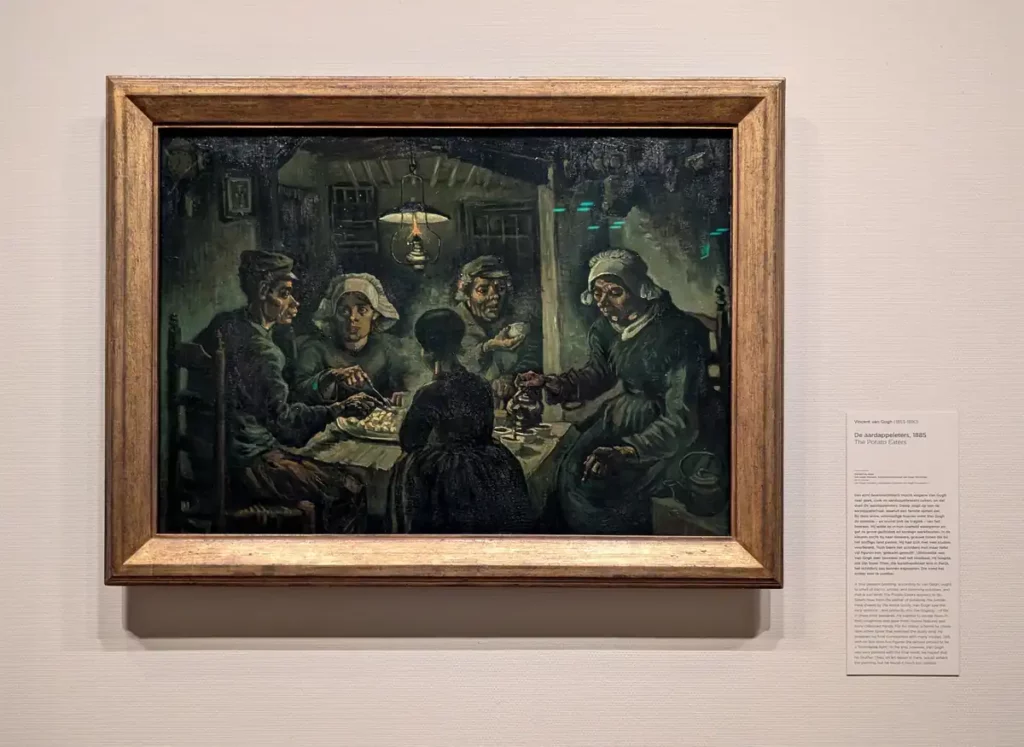 Van Gogh's The Potato Eaters painting displayed on a wall in the museum