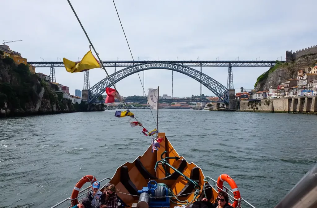 The prow of a traditional boat about to pass under Porto's famous Dom Luís bridge