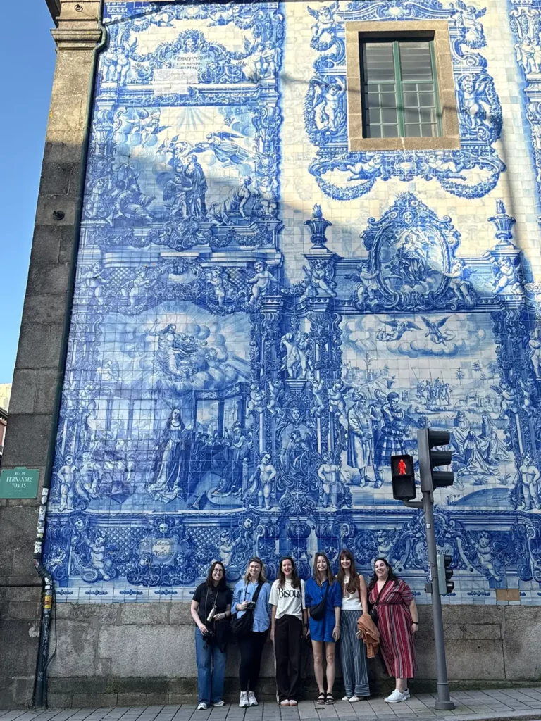 A group of women outside the Chapel of Souls, with its large painted tiles