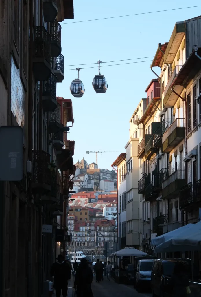 The Porto cable car peeking out from between tall houses. The Ribeira district is across the river.