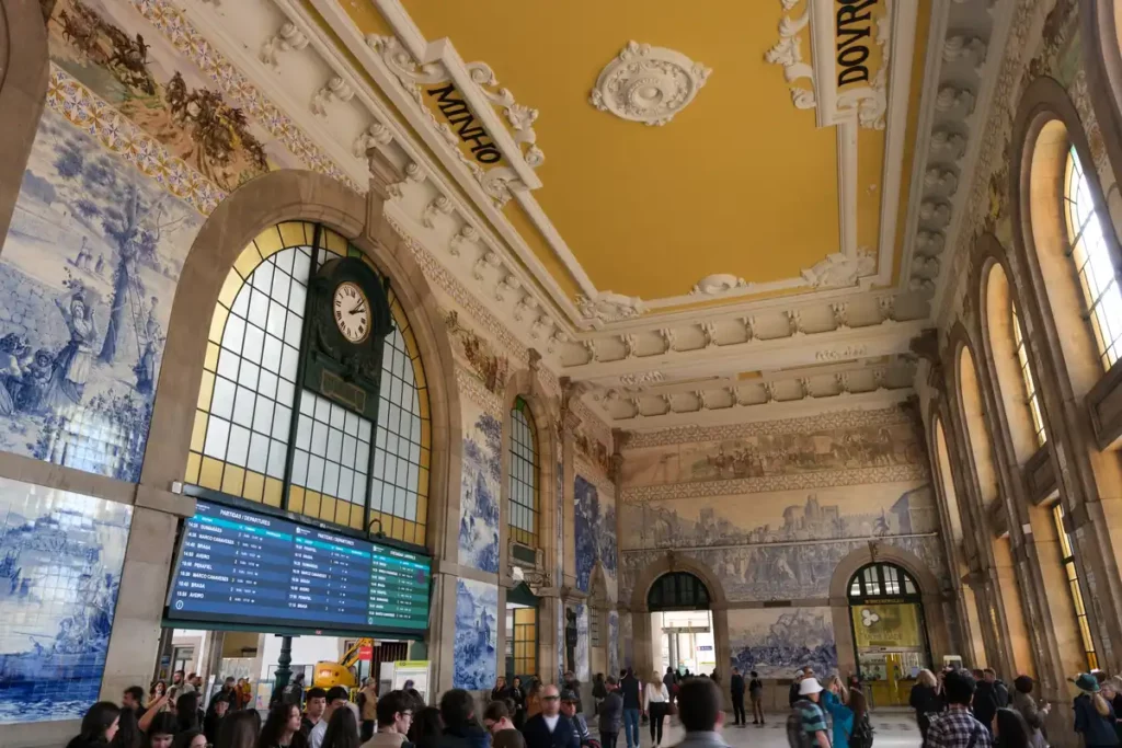 The entrance hall of São Bento railway station is covered in blue and white tiles showing stories from Portuguese history