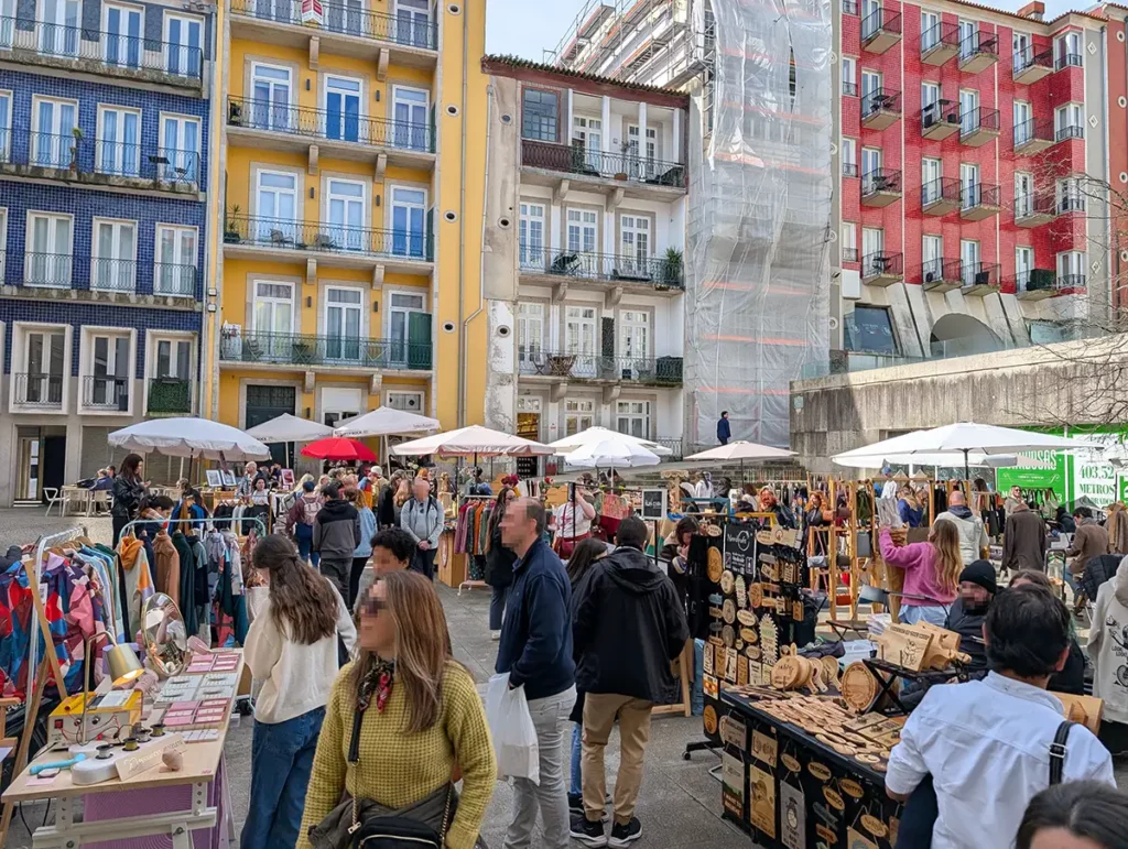 A busy craft and vintage market with colourful buildings in the background