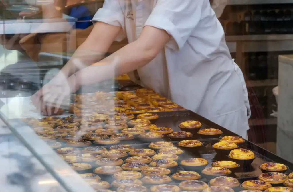 A worker making pasteis de nata in a bakery in Porto